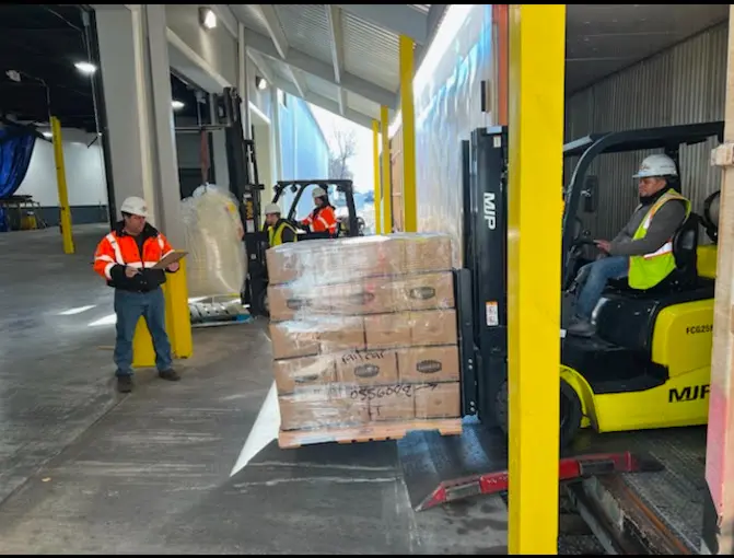 Forklift loading pallets onto a truck.
