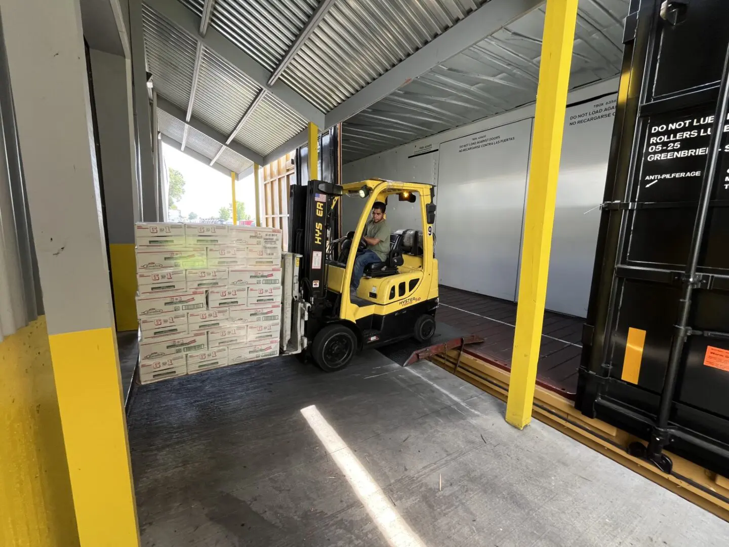 Forklift loading boxes onto a truck.
